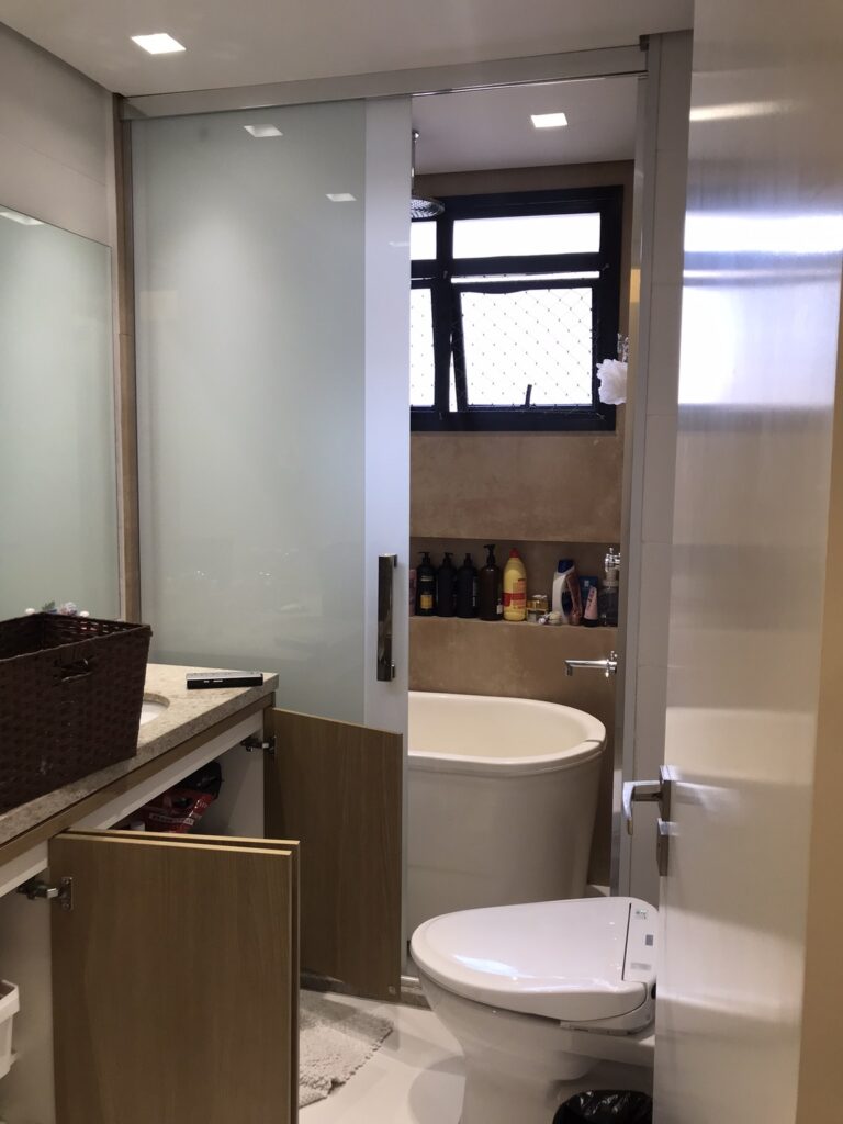 Banheiro da suíte master antes do home staging com acúmulo de itens e baixa organização