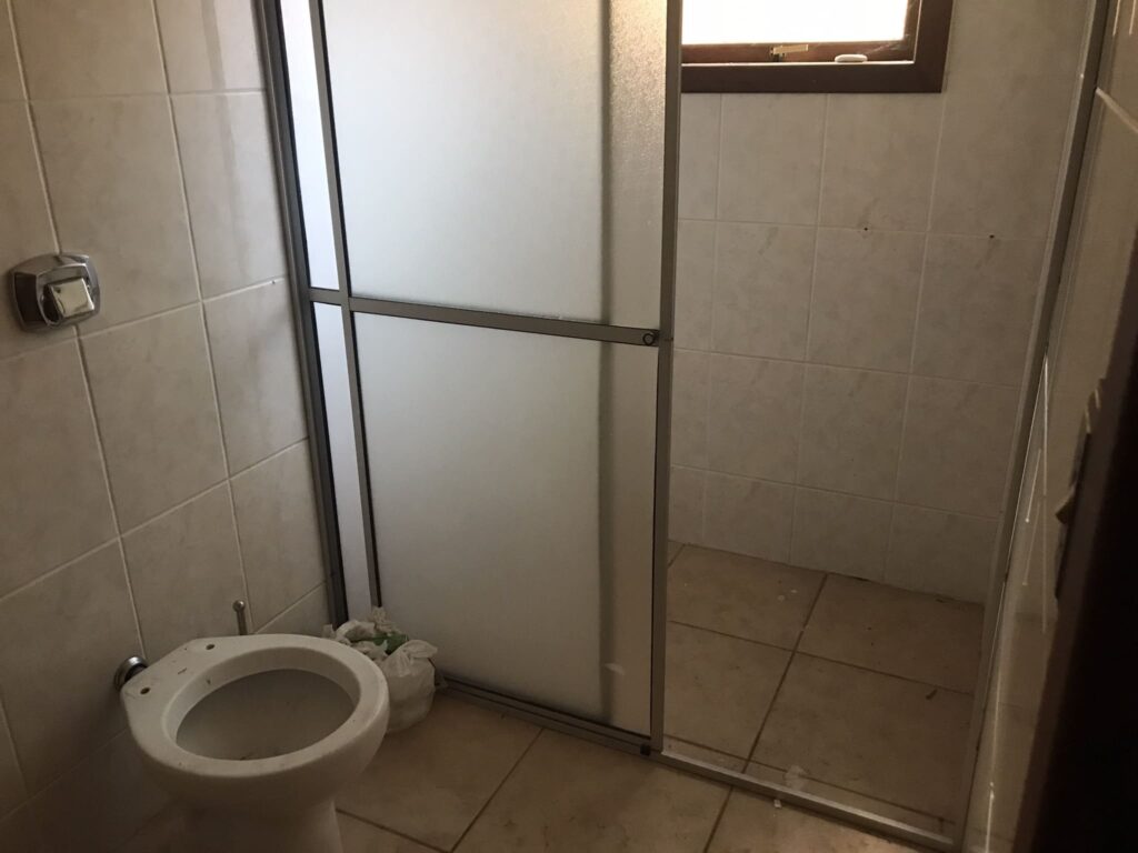 Antes: Banheiro com revestimentos antigos antes da reforma