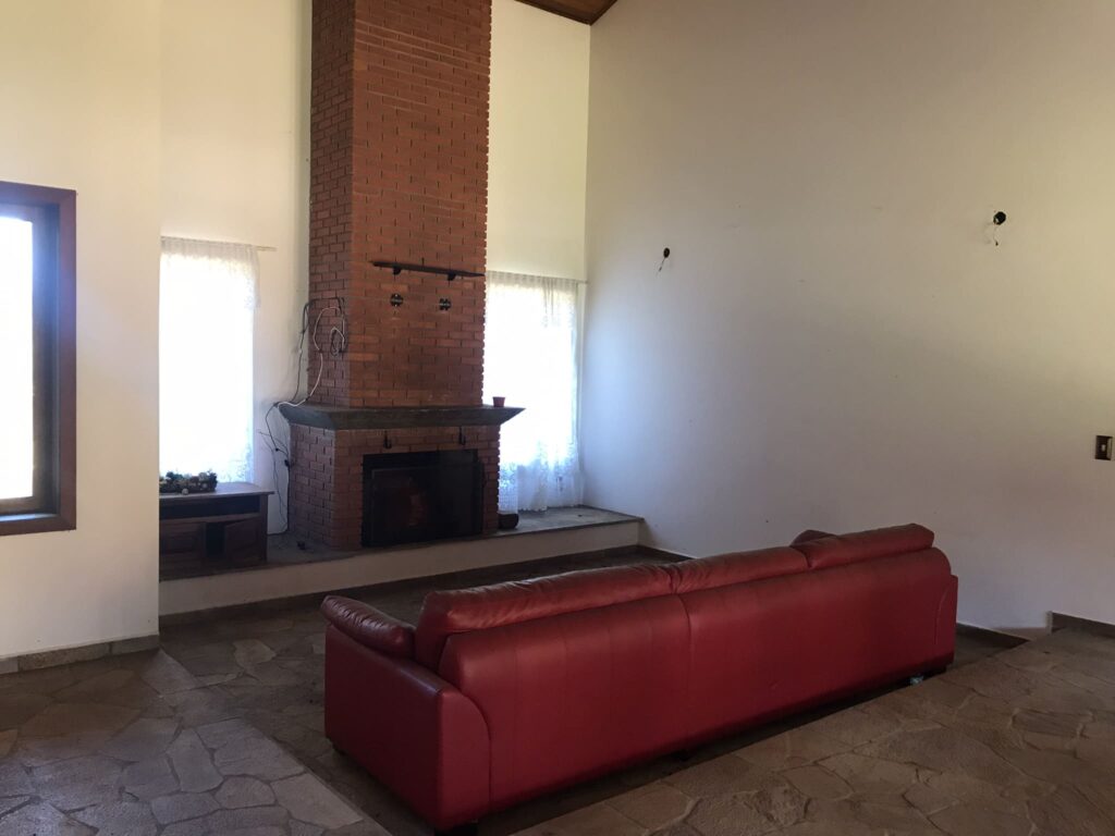 Antes: Sala de estar vazia com pé-direito alto antes do home staging